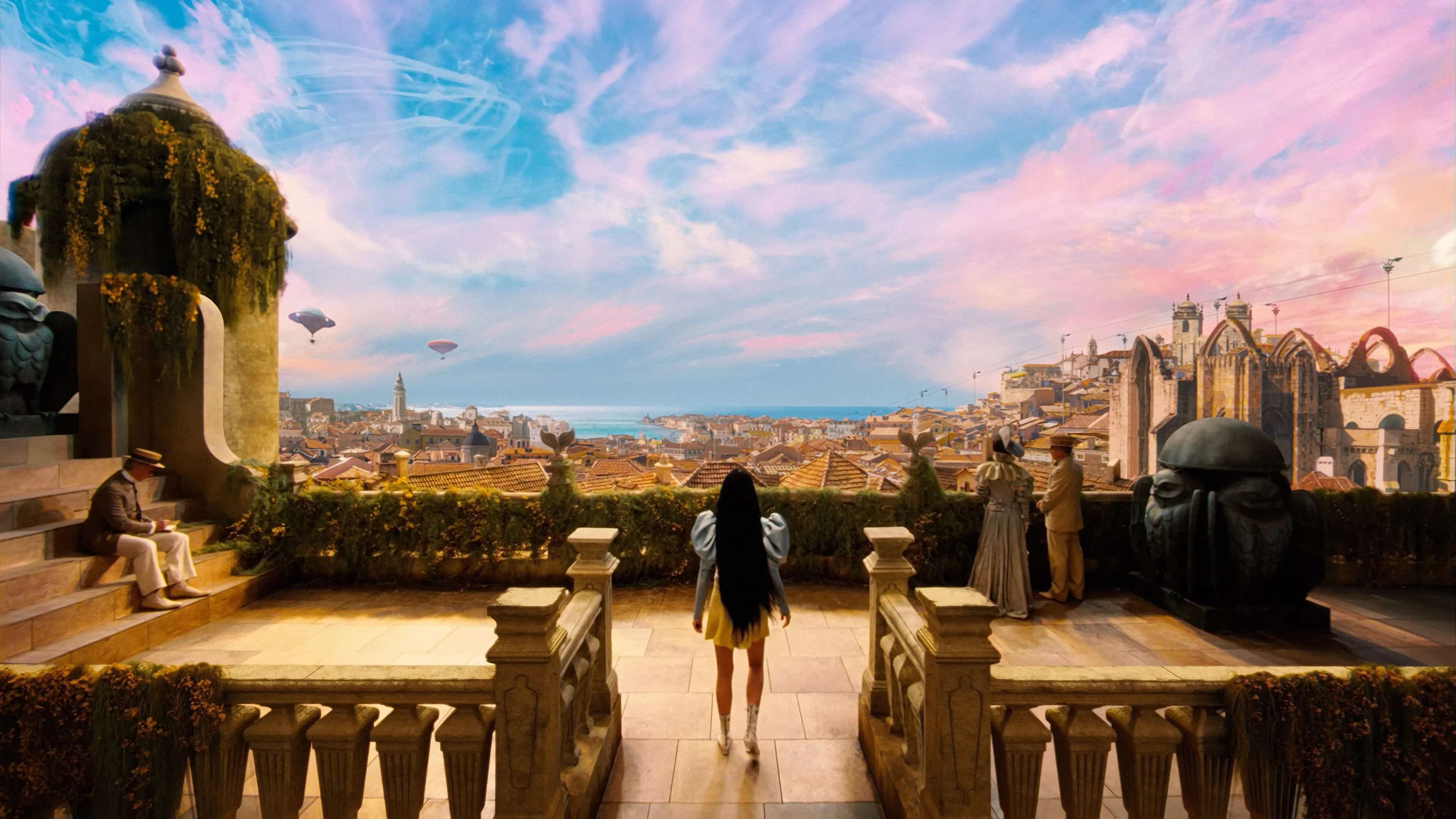 A woman stands on a large balcony overseeing a colurful steampunk city